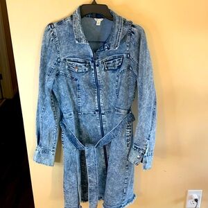 Denim dress with side slit and front pockets. Zip front closure and belt